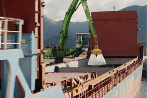 Olivine is loaded onto a ship for transport across the ocean